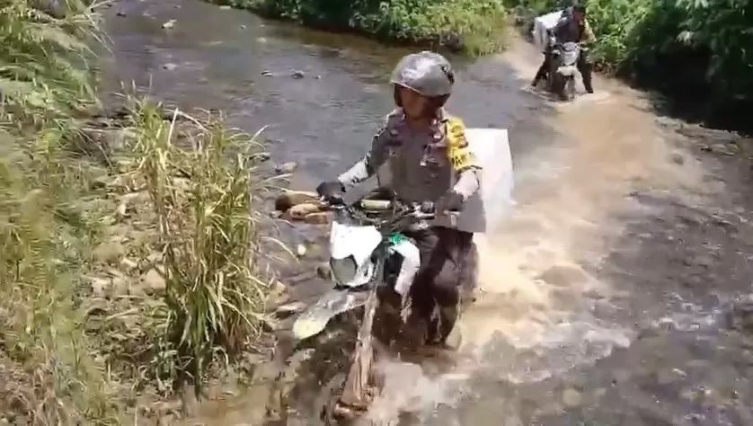 DISTRIBUSI LOGISTIK : Personel Polres Sintang saat melewati medan berat dalam pendistribusian logistik Pemilu 2024. (POLRES SINTANG )