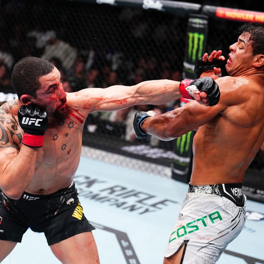 Hook kiri Robert Whittaker menghantam wajah Paulo Costa.