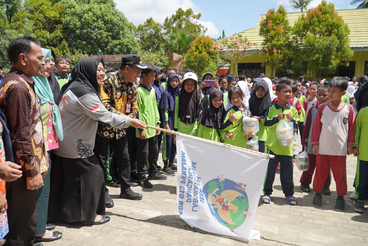 PEMBUKAAN: Pj Bupati PPU Makmur Marbun bersama Rusmilawati membuka start untuk murid SD 013 Giri Mukti Kecamatan Penajam dalam pembagian makanan bergizi dalam kegiatan SLP, Sabtu (17/2).