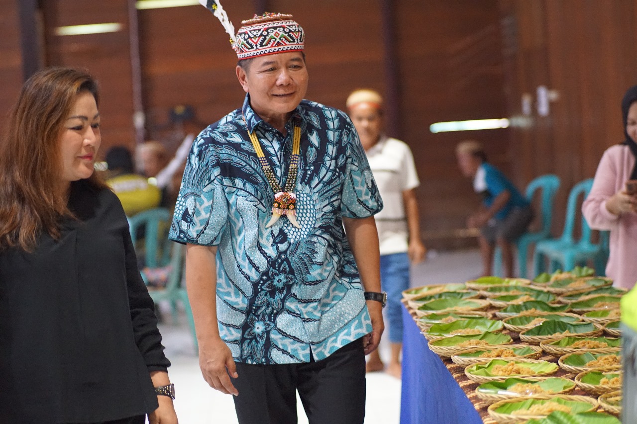 PRODUK: Bupati Bonifasius Belawan Geh dan Ketua DPRD Novita Bulan melihat emping beras hasil tumbukan pada acara Lali Ataq di Lamin Adat Ujoh Bilang, Minggu (18/2).