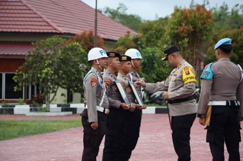 DIPECAT: Kapolres Gumas AKBP Theodorus Priyo Santosa memberi tanda silang di foto dua personel Polri yang dipecat, Kamis (22/2/2024). (HUMAS POLRES GUNUNG MAS FOR RADAR SAMPIT)