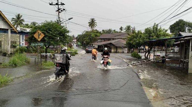 BANJIR: Sejumlah pengendara melintas di Jalan Beliang yang tergenang air.