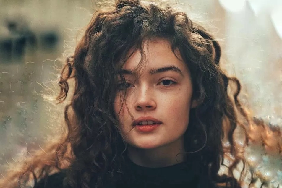 Ilustrasi perempuan cantik menawan dengan rambut ikal sedang menatap ke arah kamera./(Pinterest/Sasha Kichigina)