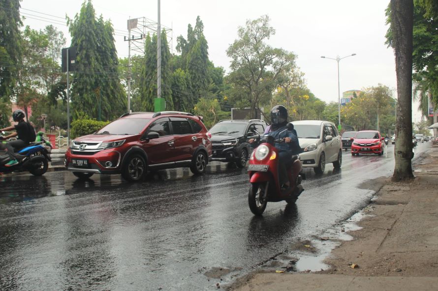 MENEMBUS HUJAN:Warga Banjarbaru melintas di ruas jalan di Kota Banjarbaru di tengah derasnya hujan yang terjadi beberapa waktu lalu.(Foto:Bayu Aditya Rahman/Radar Banjarmasin)