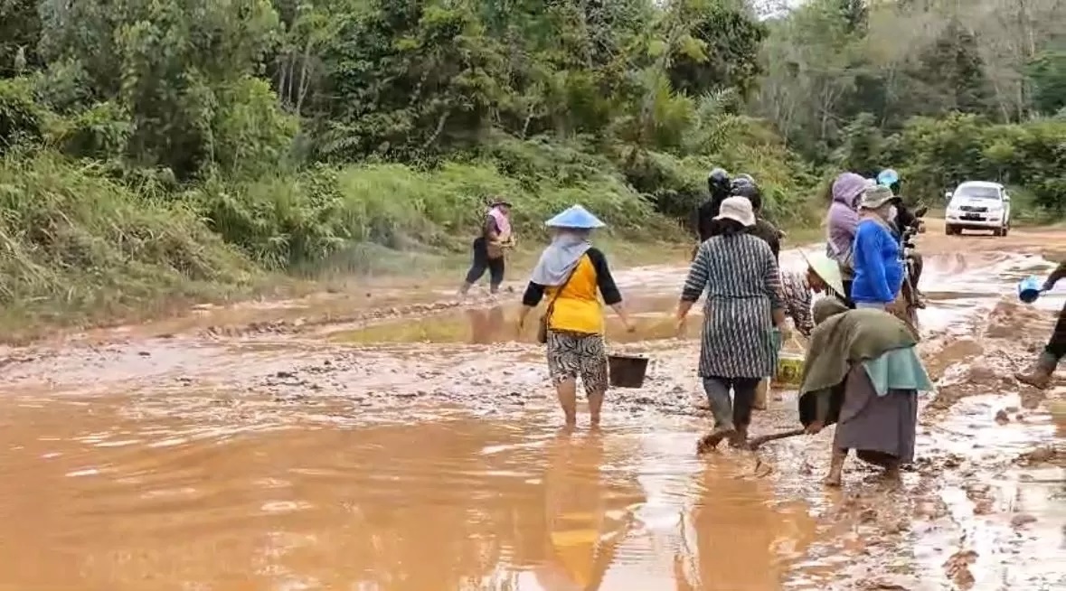 KURAS GENANGAN : Ibu-ibu di Desa Semadin Lengkong Kecamatan Nanga Pinoh Kabupaten Melawi, menguras kubangan air di ruas jalan Nanga Pinoh-Ella Hilir, pada Senin (4/3). (ISTIMEWA)
