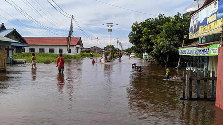 BERENANG: Banjir yang melanda sejumlah lokasi di Kota Palangka Raya merendam akses warga. Di jalan menuju Pelabuhan Flamboyan Bawah, anak-anak bermain air dan berenang di tengah jalan.