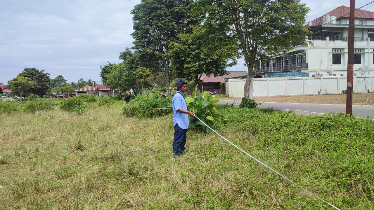 DIUKUR: Petugas mengukur luas lahan Lapangan Gunung Seteleng, Kecamatan Penajam, PPU yang akan dibebaskan pemerintah.(ist)