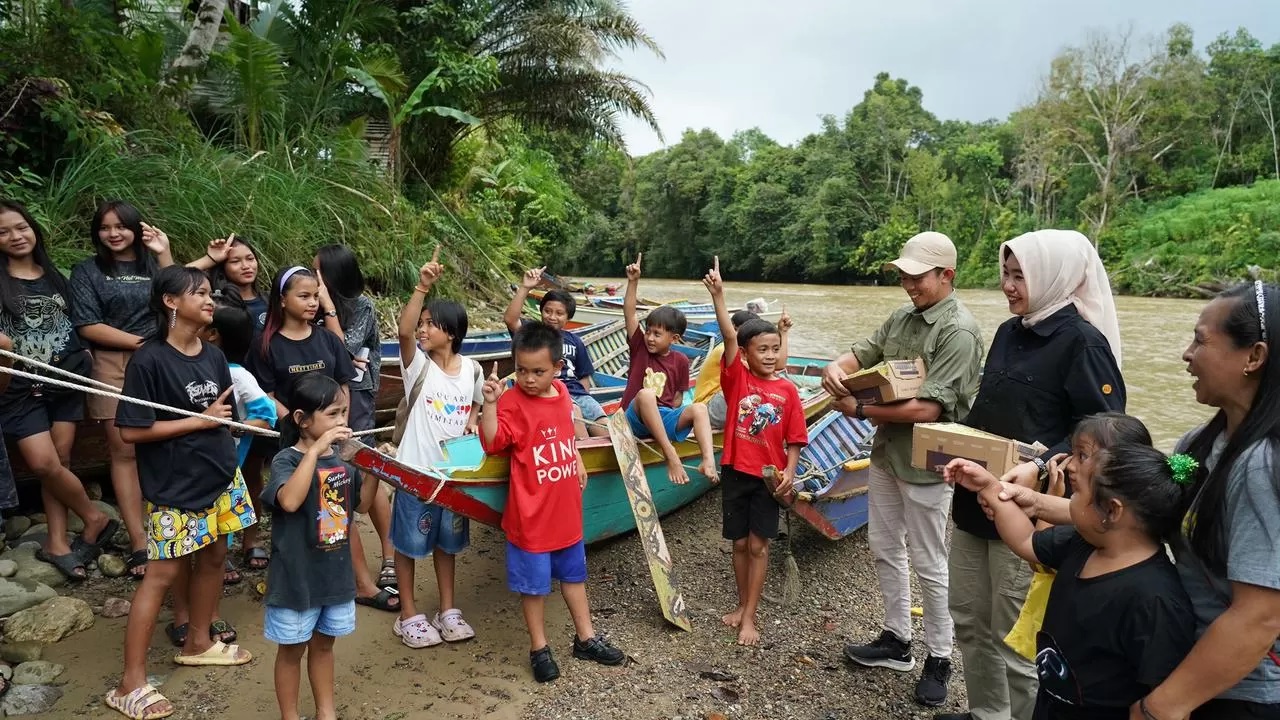 ANAK PEDALAMAN: Sampai di Desa Tanjung Lokang, Kadisdikbud Kalbar Rita Hastarita membagikan susu dan kue buat anak-anak pedalaman di Desa Tanjung Lokang. (MIRZA/PONTIANAKPOST&nbsp;)
