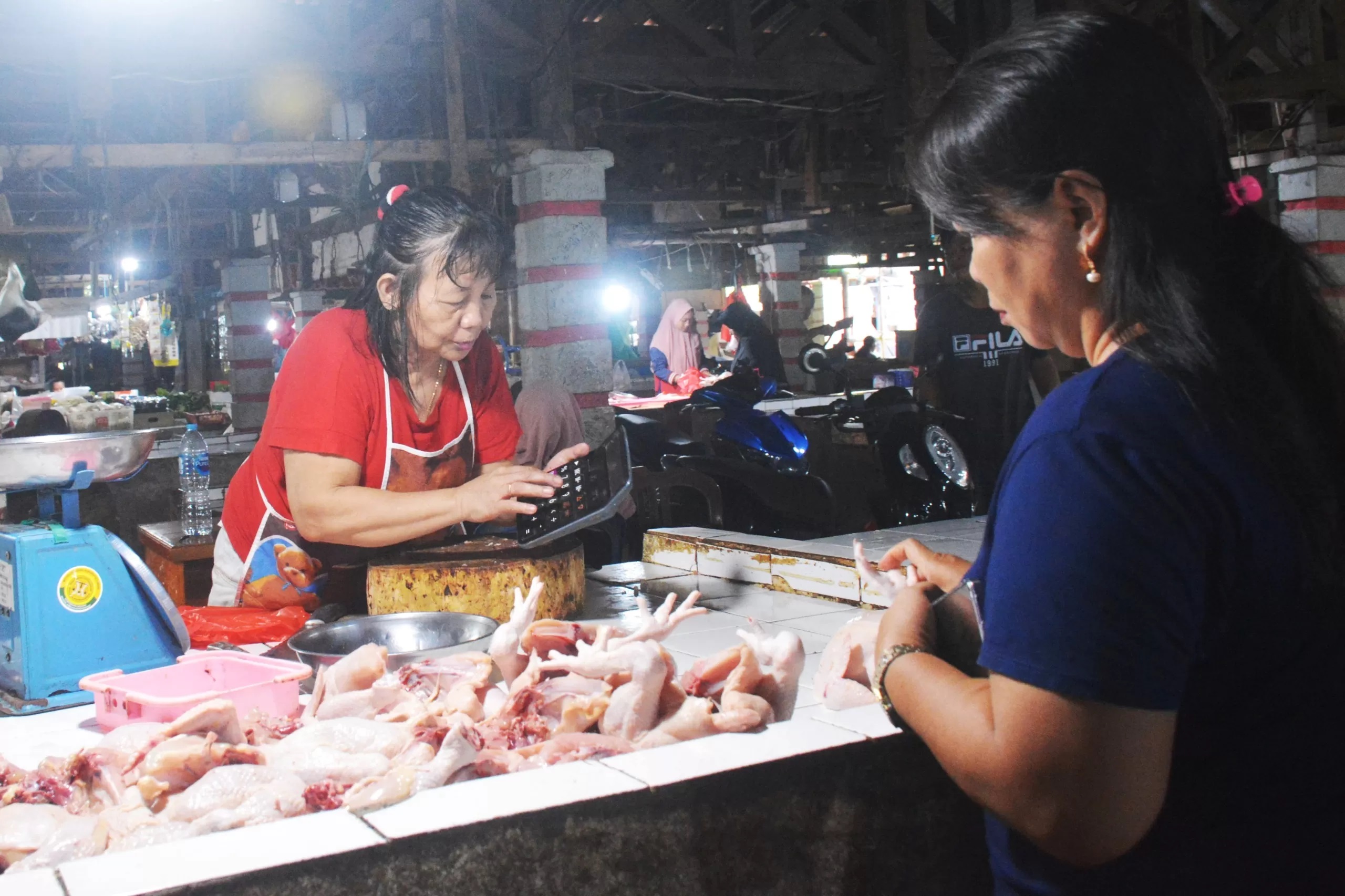 JUALAN: Seorang pedagang ayam potong di Pasar Rakyat Landak, Ngabang melayani pembeli, Selasa (13/3) lalu. Belakangan harga daging ayam meroket. (MIFTAHUL KHAIR/PONTIANAKPOST)