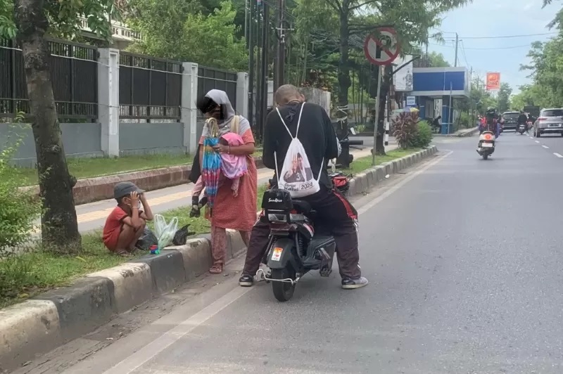 TANGAN DI BAWAH: Pengemis mangkal di depan kampus ULM, Jalan Hasan Basry, Banjarmasin Utara. Dipotret Jumat (15/3) siang.&nbsp; (FOTO; ENDANG SYARIFUDDIN/RADAR BANJARMASIN)