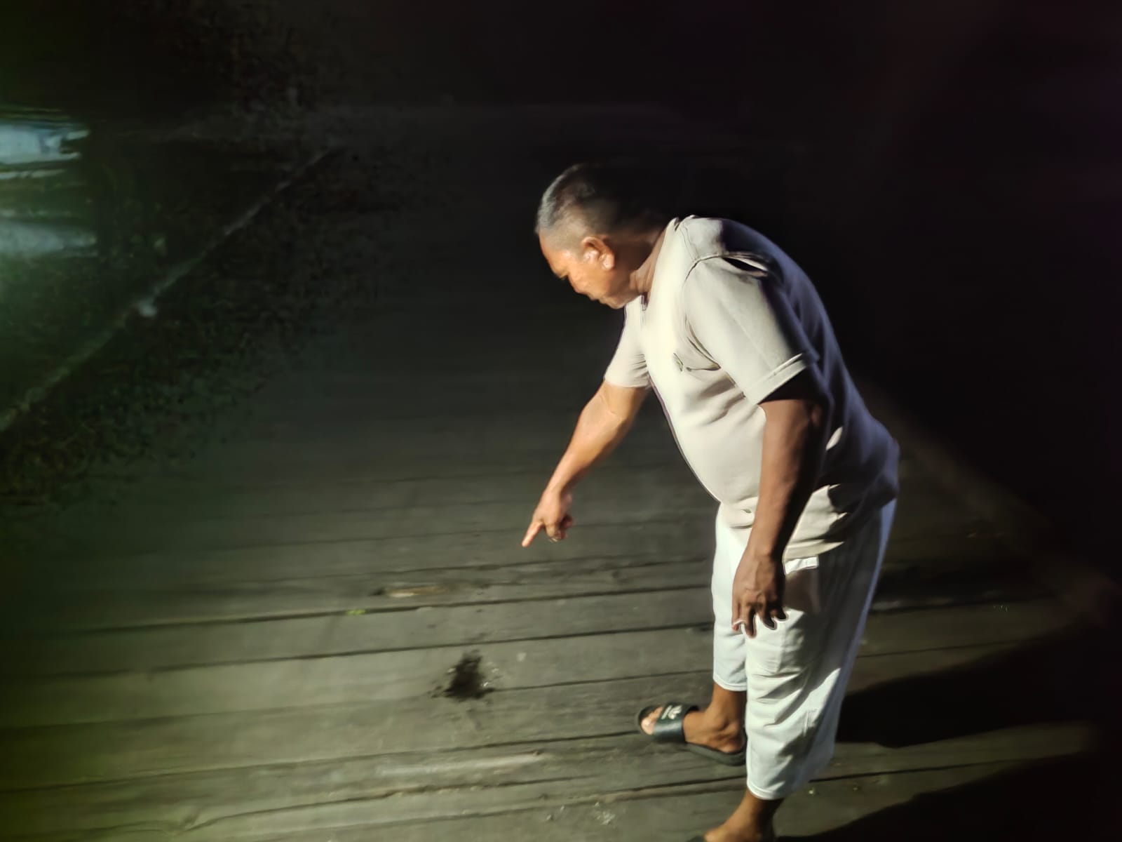 LOKASI KEJADIAN: Warga saat memperlihatkan bercak darah di lokasi duel maut dermaga pelabuhan gudang gembor, Jalan Iskandar 22, Sampit, Senin (18/3/2024) dini hari. (FAHRY/RADAR SAMPIT)