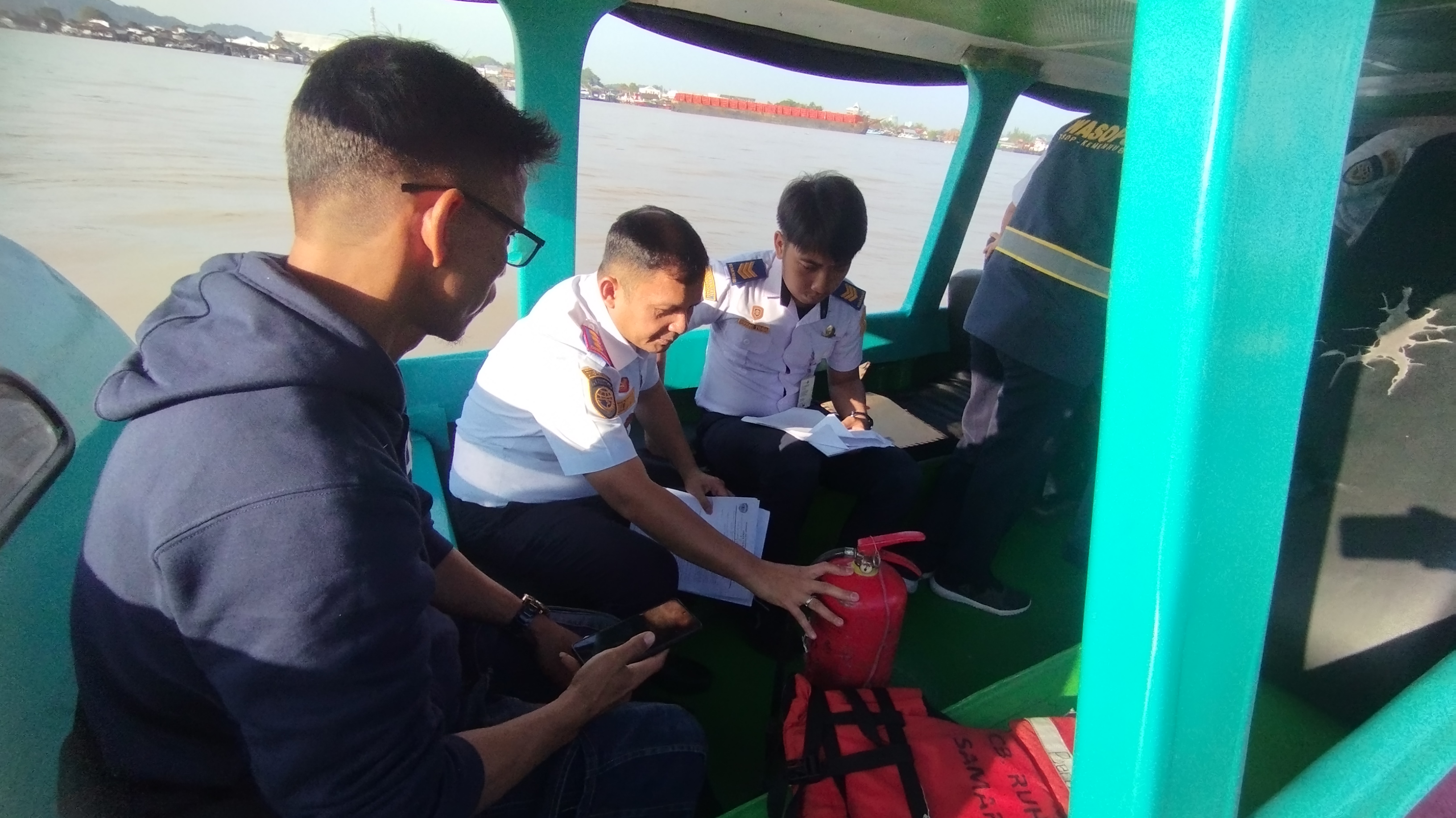 PEMERIKSAAN: Hotmarulitua Manalu dan Richi Briantoro mengamankan beberapa perangkat keselamatan yang tidak layak dalam agenda pengecekan di Dermaga Mahakam Ilir, Kecamatan Samarinda Kota, Rabu (20/3).