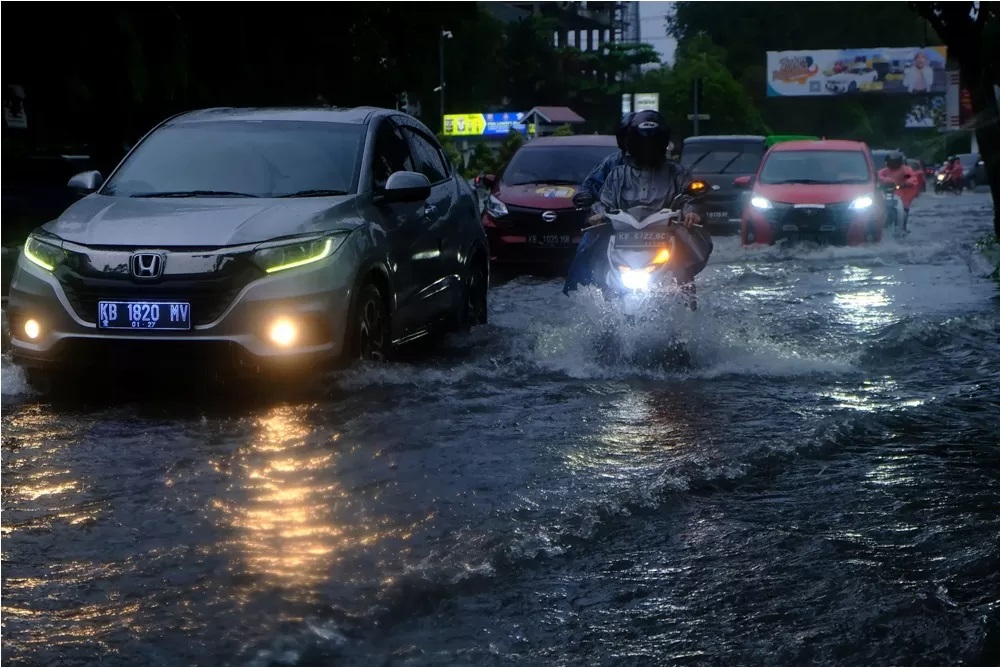 Sejumlah pengendara motor dan mobil melintasi banjir di Jalan KH Ahmad Dahlan, Pontianak, Kalimantan Barat, Jumat (8/3/2024). (