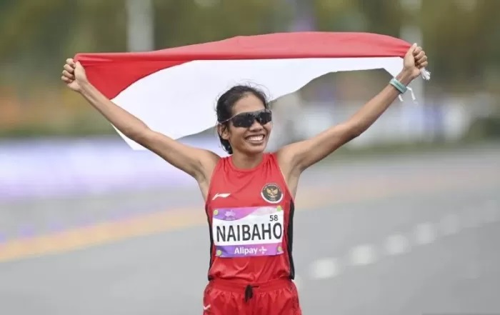 Pelari Indonesia Odekta Elvina Naibaho mengibarkan bendera Merah Putih usai melewati garis finis pada final marathon putri Asian Games 2022 di Qiantang River Green Belt, Hangzhou, Tiongkok.