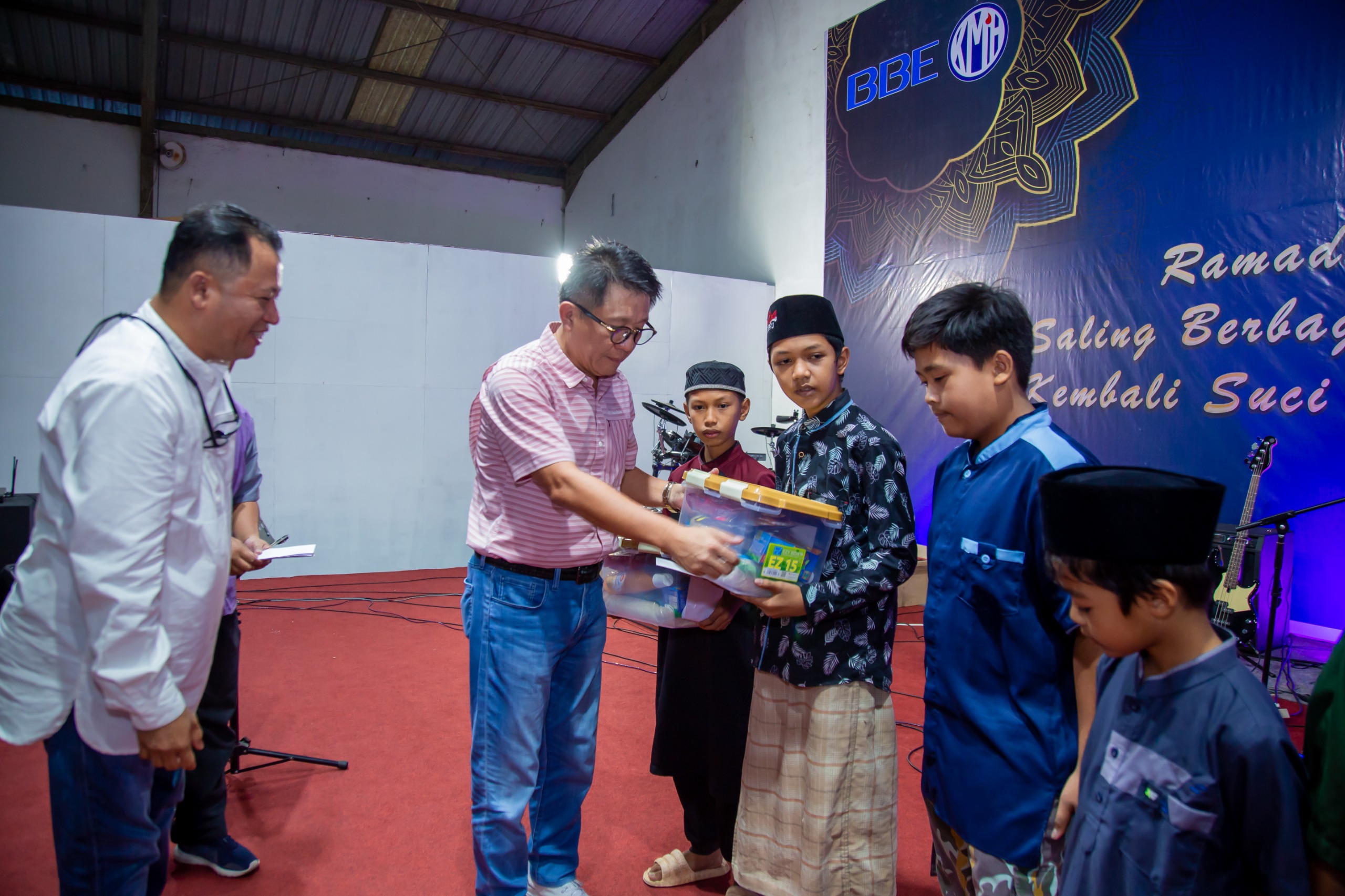 Ricky Gowdjali didampingi Reno Barus (kiri) menyerahkan santunan kepada anak yatim lingkar tambang pada acara Bukber (IST)
