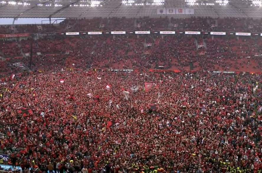 Fans Bayern Leverkusen turun ke lapangan merayakan kemenangan.