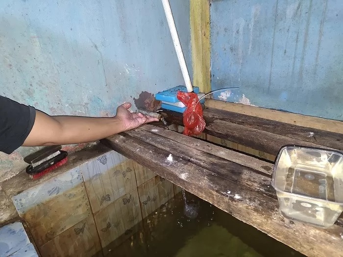 AIR PDAM: Warga Ngabang menunjukkan aliran PDAM di rumahnya yang kecil, beberapa waktu lalu. (MIFTAHUL KHAIR/PONTIANAK POST)