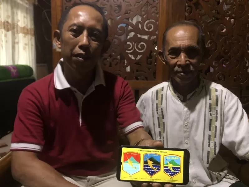 PUNYA MAKNA: Roni bersama H Mahmud memperlihatkan lambang Pemkab Kotabaru. (FOTO: Jumain/ Radar Banjarmasin.)