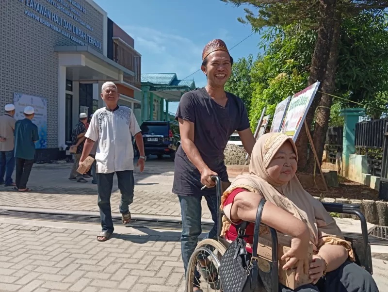 IKUTI MANASIK: Nisfiani (51) didorong oleh keponakannya usai mengikuti manasik haji di Kankemenag Tapin. (Foto: Rasidi Fadli/Radar Banjarmasin)