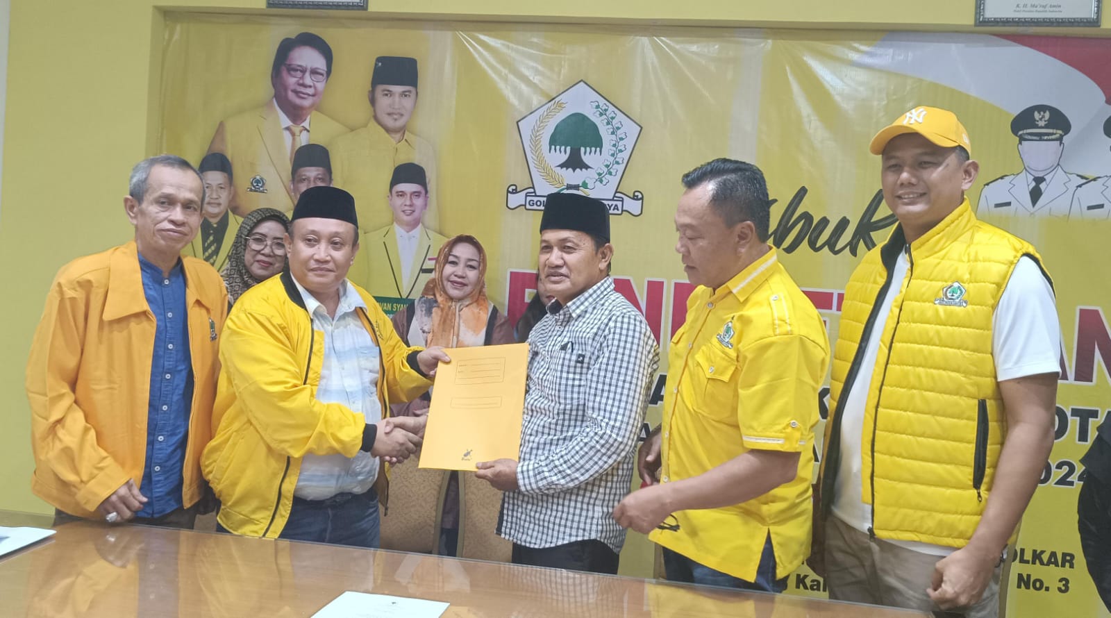 Ketua Tim Pendaftaran Penjaringan Calon Walikota dan Wakil Walikota Partai Golkar Samarinda, H Andi Saharuddin mengenakan songkok peci dan jaket kuning menyerahkan formulir pendaftaran.