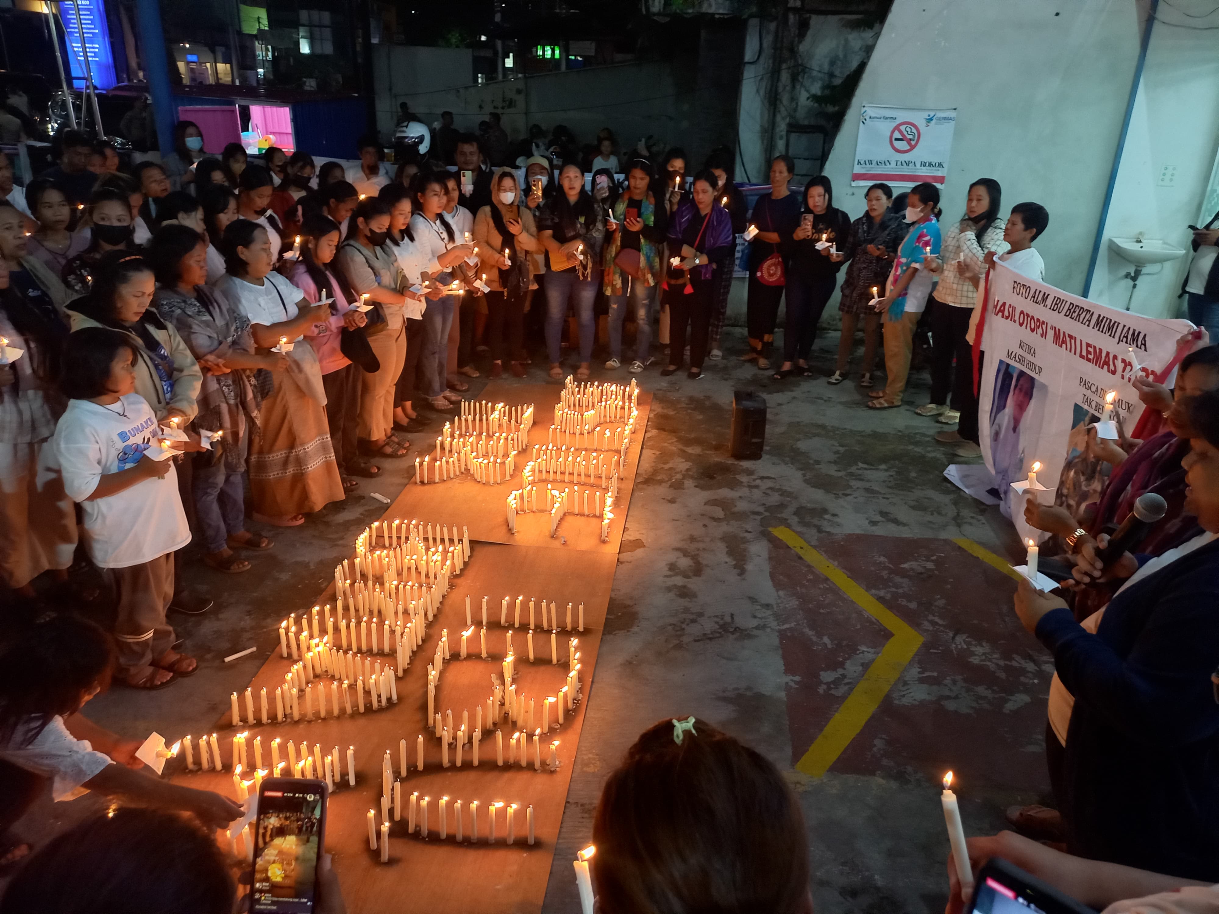 LILIN HARAPAN: Keluarga dan simpatisan mendiang Berta Mirni Jaya melangsungkan doa di pelataran Kimia Farma, Jalan P Hidayatullah, Kamis (18/4) malam.