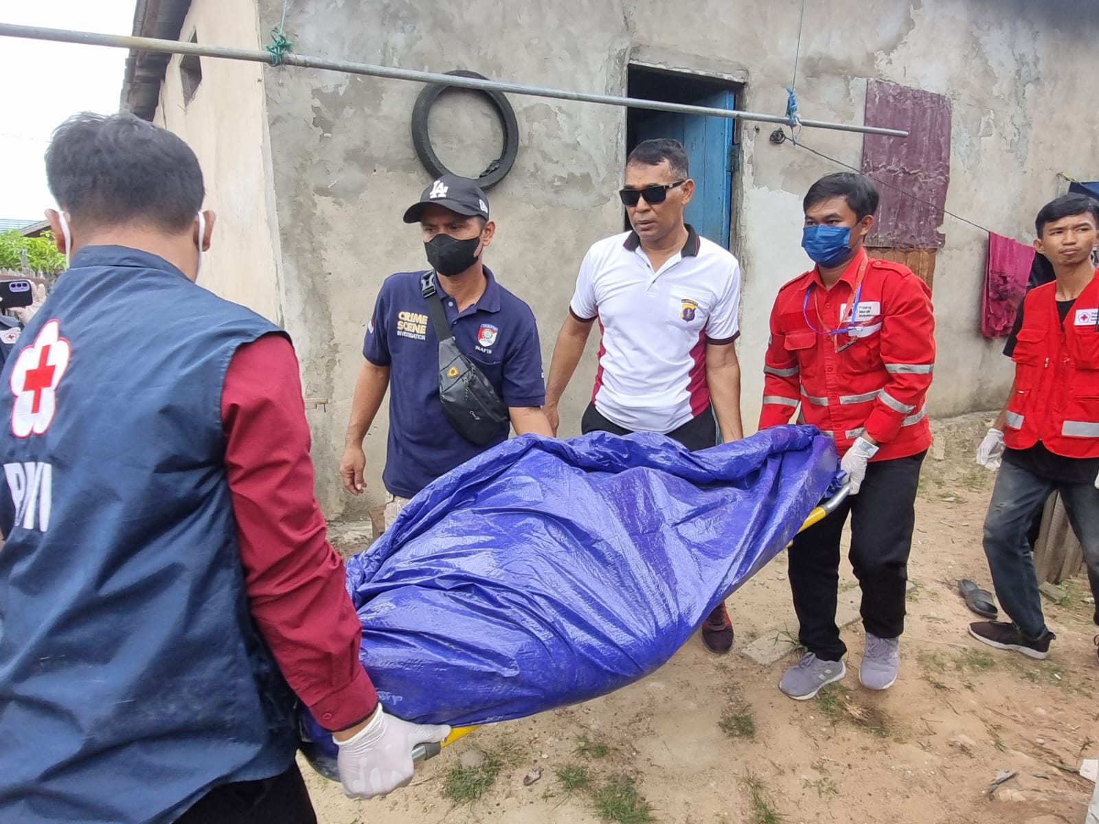 PERISTIWA: Petugas mengevakuasi jasad korban.