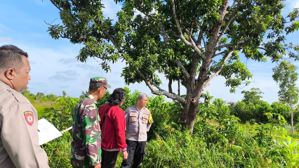 PENYELIDIKAN: Polisi berada di sekitar pohon tempat korban gantung diri ditemukan. (Polres Batola untuk Radar Banjarmasin)