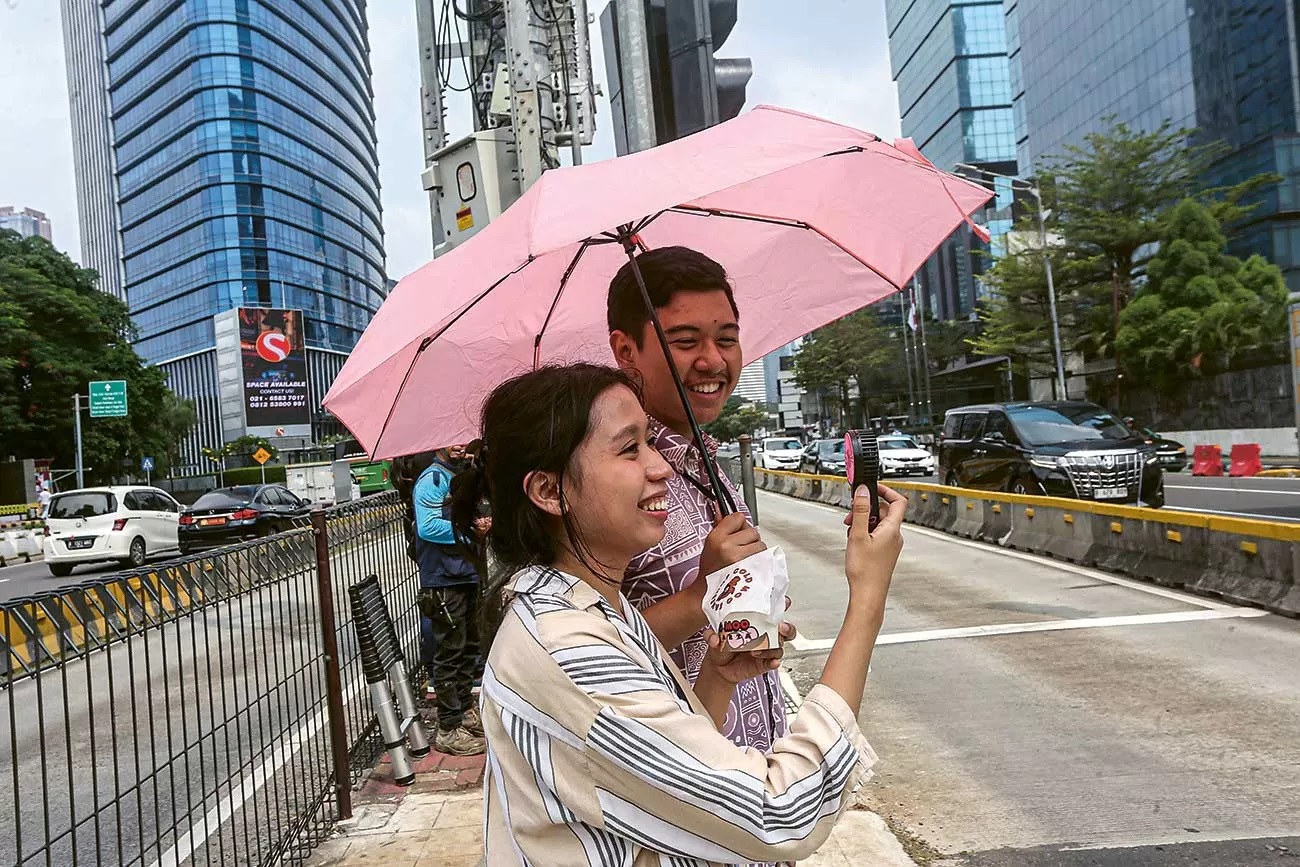 HINDARI TERIK: Pejalan kaki menggunakan payung untuk menghindari terik matahari di Jakarta, Kamis (2/5). (MIFTAHUL HAYAT/JAWA POS)