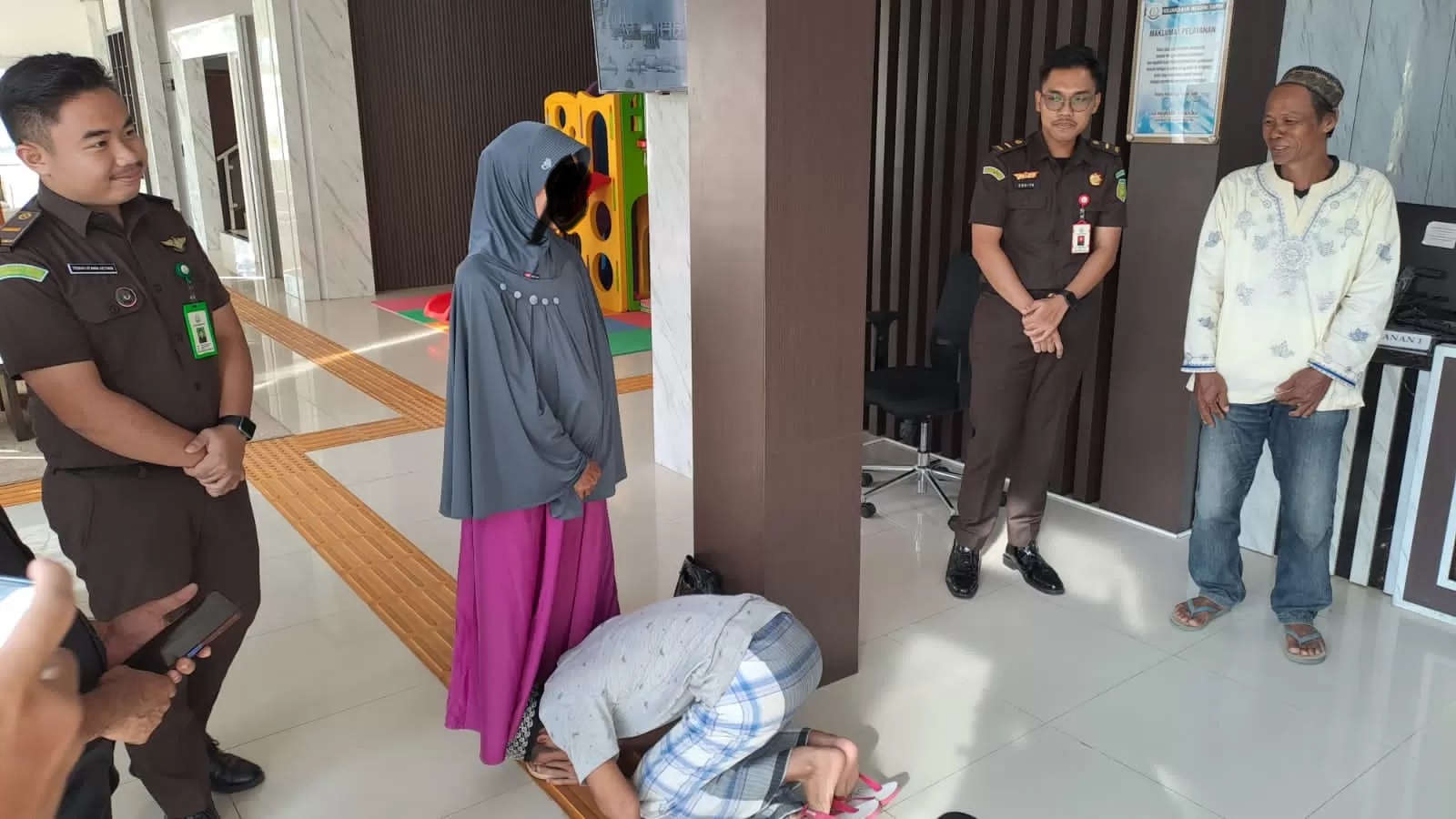 CIUM KAKI: AH langsung mencium kaki ibunya, setelah dibebaskan Kejari Tapin dalam kasus ayah ditusuk anak. (Foto: Kejari Tapin untuk Radar Banjarmasin)
