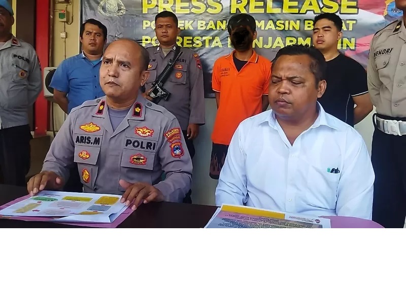 RILIS KASUS: Tersangka Armando (21) di belakang Kapolsek Banjarmasin Barat Kompol Aris Munandar. (FOTO: MAULANA/RADAR BANJARMASIN)