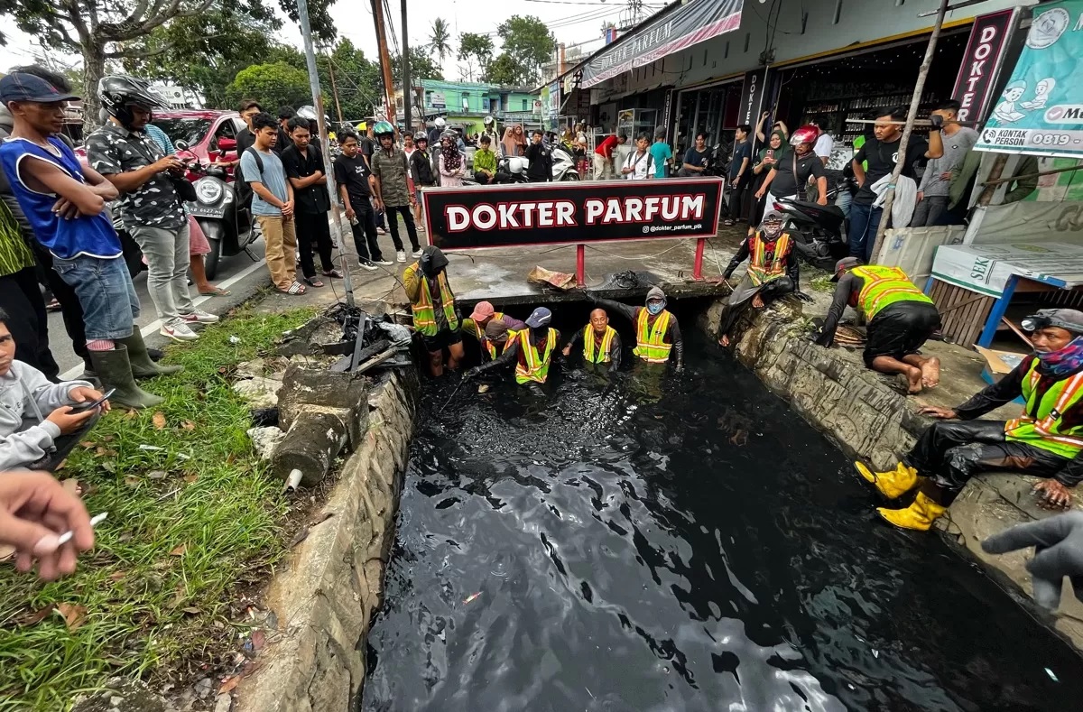 Petugas drainase bersama anggota Polresta Pontianak mencari potongan tulang di selokan Jalan Danau Sentarum. (Shando Safela)