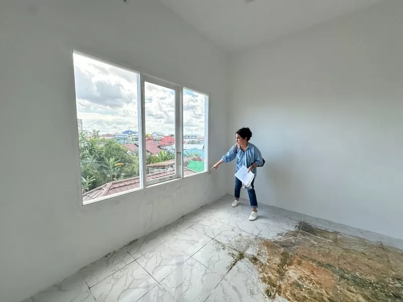 BELUM SELESAI: Merry menunjukkan bangunan kos-kosan lantai tiga di Jalan Rambai Padi, Banjarmasin Utara, yang belum selesai dikerjakan kontraktor Badri. | Foto: Muhammad Oscar Fraby/Radar Banjarmasin