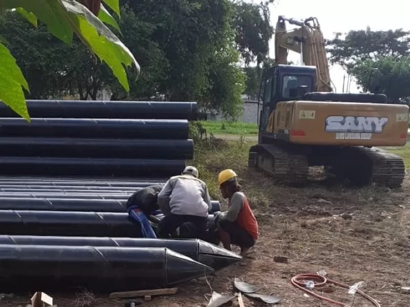 MULAI DIKERJAKAN: Pekerja proyek pembangunan jembatan di perempatan Guntung Manggis mulai meruncingkan pipa pancang. (FOTO: FADLAN ZAKIRI /RADAR BANJARMASIN)