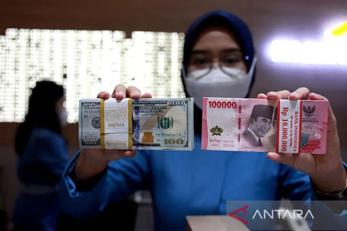 Ilustrasi - Petugas perbankan menunjukkan uang dolar AS dan uang rupiah. ANTARA FOTO/Reno Esnir/tom/pri.