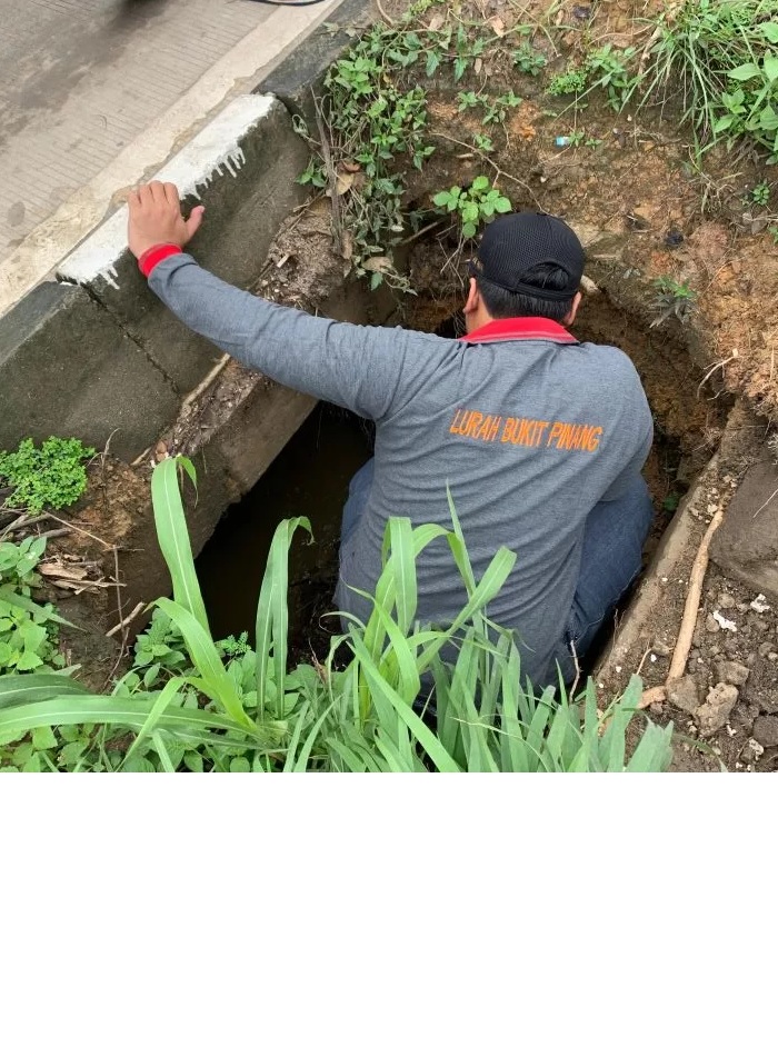 DIDUGA PENYEBAB. Lurah Bukit Pinang, Eko Purwanto saat mengecek gorong-gorong yang menyebabkan air meluap hingga menyebabkan genangan parah di Jalan Poros Samarinda-Tenggarong. (rin/Sapos)