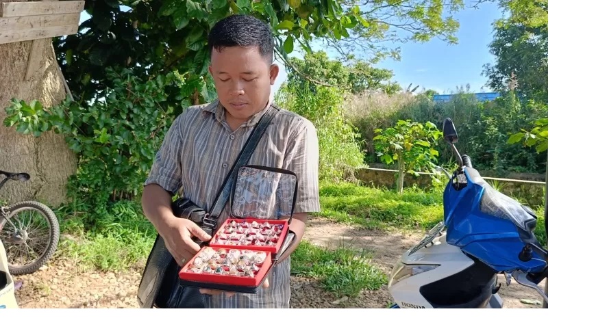 SEMANGAT: Roni saat memperlihatkan deretan batu akik miliknya untuk dijual kepada wisatawan. (Foto: Sheilla Farazela/Radar Banjarmasin)