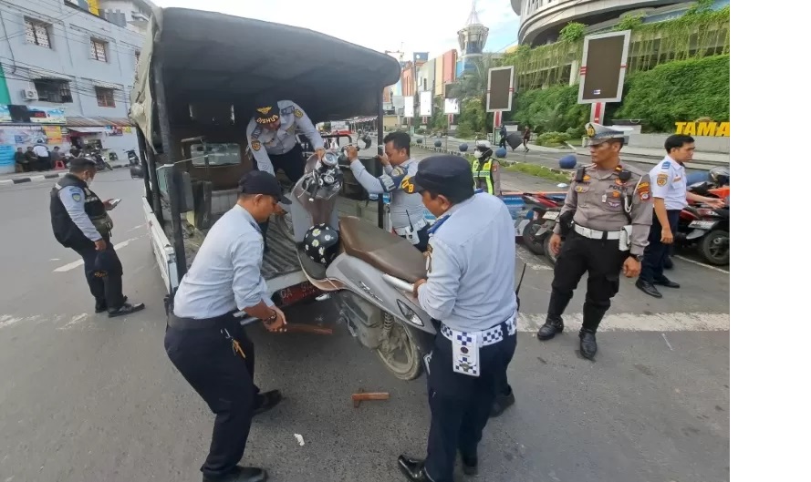 DIANGKUT PETUGAS: Delapan buah sepeda motor yang parkir di bahu Jalan Simpang Ulin diangkut dan dibawa petugas ke Mapolresta Banjarmasin. (Foto: Wahyu Ramadhan/Radar Banjarmasin)