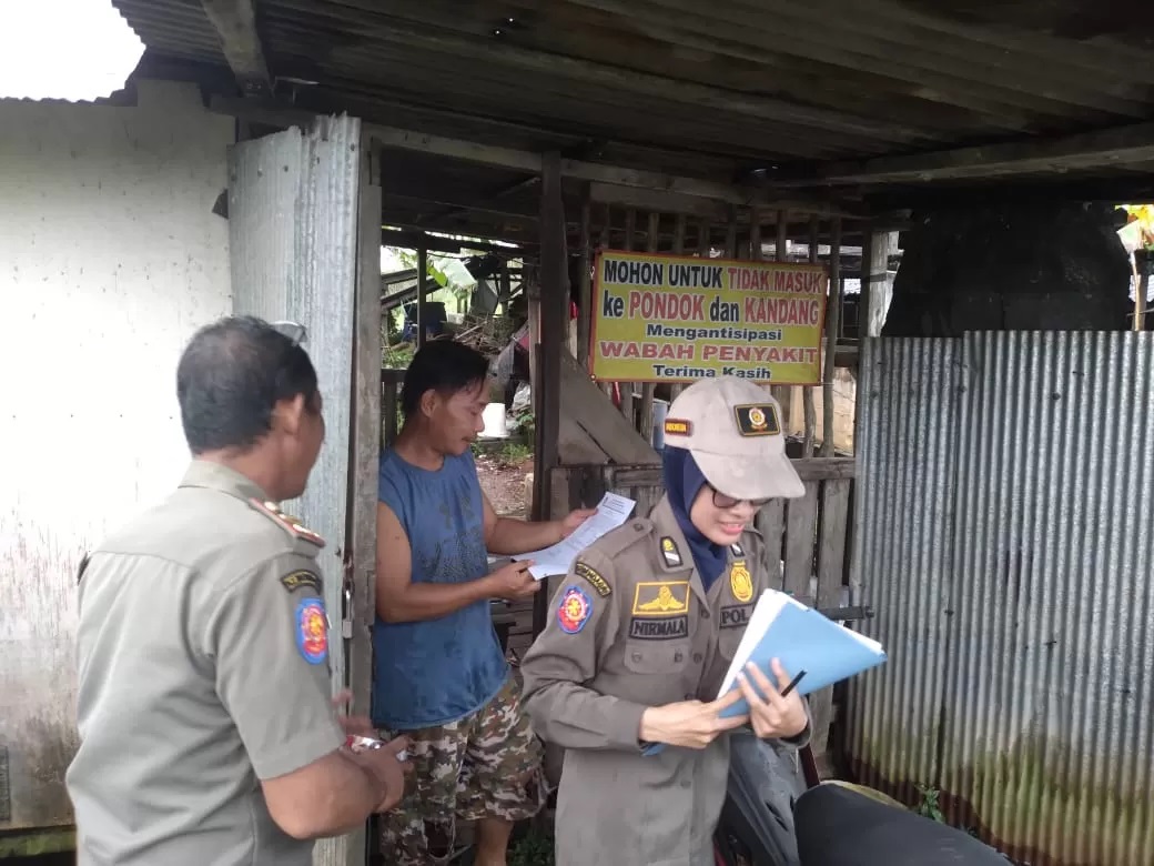 PERINGATAN: Petugas Satpol PP Banjarbaru saat menyampaikan surat peringatan pertama kepada para peternak babi. (Foto: Satpol PP Banjarbaru)