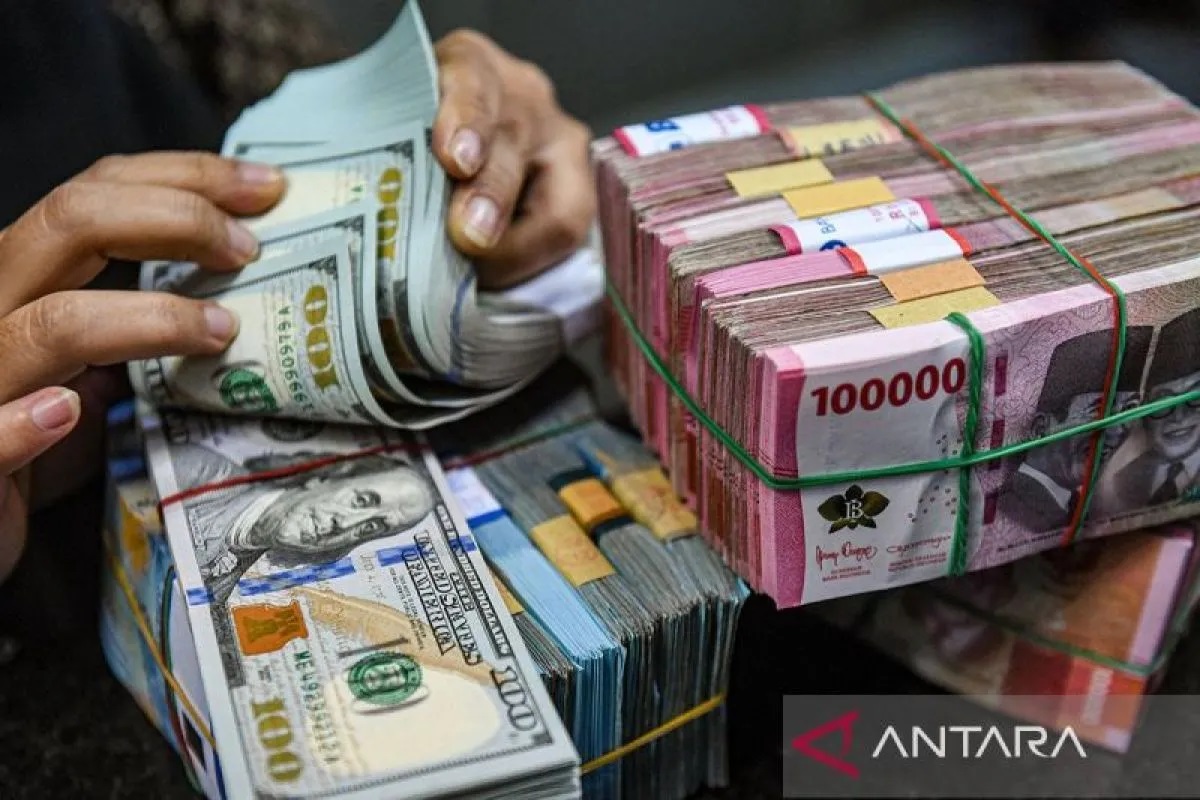 Petugas menghitung uang pecahan dolar AS dan rupiah.