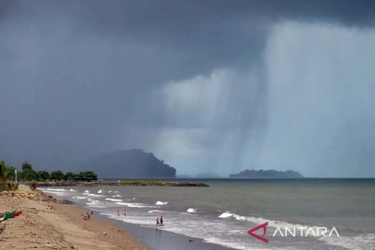 Ilustrasi - Warga bermain ombak sebelum hujan badai tiba di Pantai Padang, Sumatera Barat, Jumat (21/6/2024). ANTARA FOTO/Iggoy el Fitra/foc/aa.