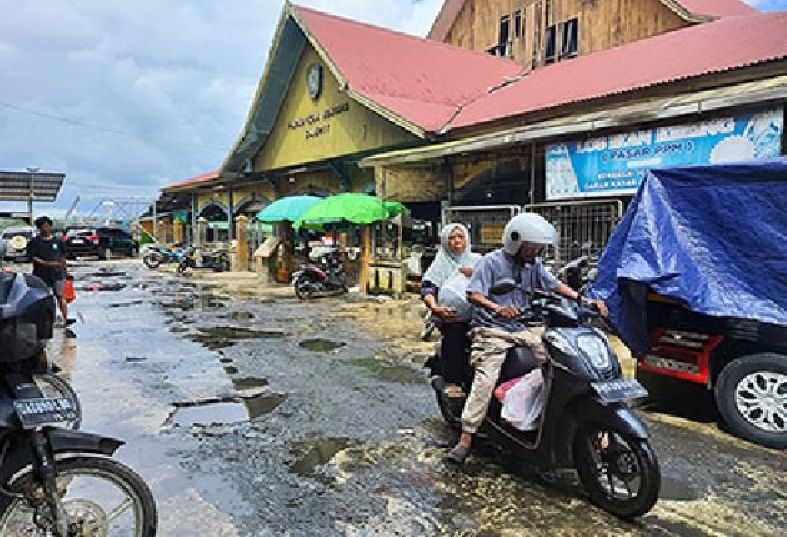 MEMPRIHATINKAN: Jalan masuk menuju Pasar Ikan Mentaya sekaligus jalan akses keluar pengunjung PPM Sampit yang rusak dan perlu perbaikan, Kamis (11/7/2024). (HENY/RADAR SAMPIT)