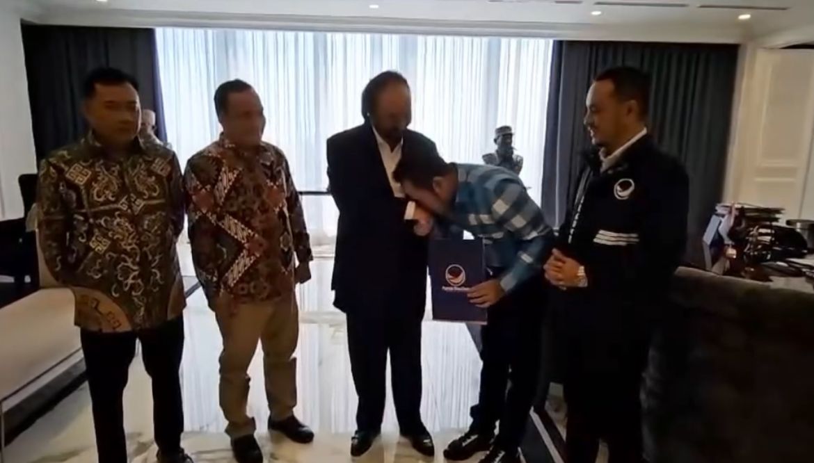 CIUM TANGAN: Rudi bersama Surya Paloh.