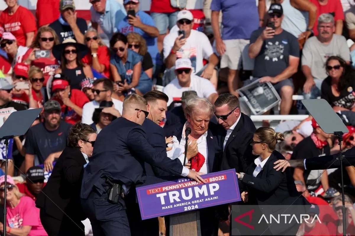 Kandidat presiden dari Partai Republik Donald Trump (tengah) dibantu personel Dinas Rahasia AS setelah terjadinya insiden penembakan saat rapat umum di Butler Farm Show, Pennsylvania, AS, Sabtu (13/7/