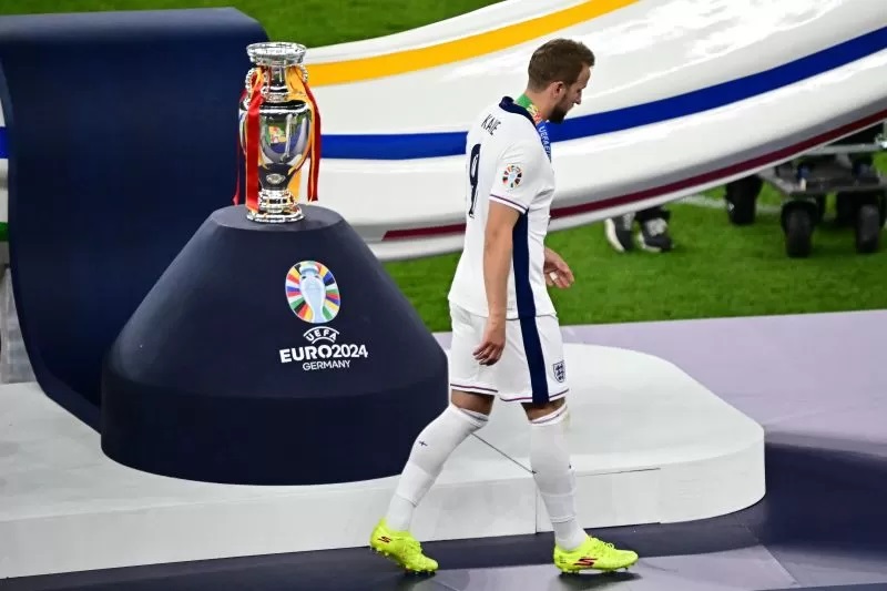 Striker timnas Inggris Harry Kane berjalan melewati trofi Piala Eropa setelah laga final Euro antara Spanyol dan Inggris di Stadion Olimpiade, Berlin, pada 14 Juli 2024. (AFP/TOBIAS SCHWARZ)