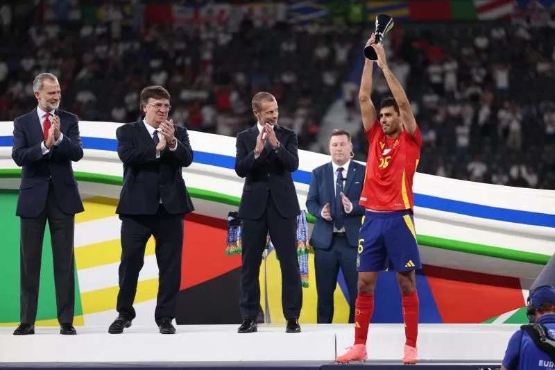 Rodri mengangkat trofi Pemain Terbaik Euro 2024 setelah laga final Spanyol melawan Inggris di Olympiastadion, Berlin, Jerman, 14 Jili 2024. (AFP/ADRIAN DENNIS)