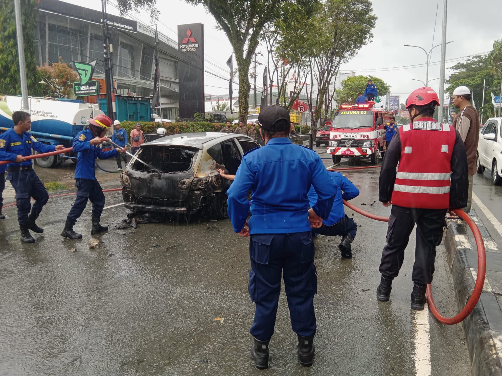 Petugas BPBD Balikpapan memadamkan api yang melahap mobil milik Heny di Jalan MT Haryono, tak jauh dari traffic light Balikpapan Baru.  (Foto : Istimewa)