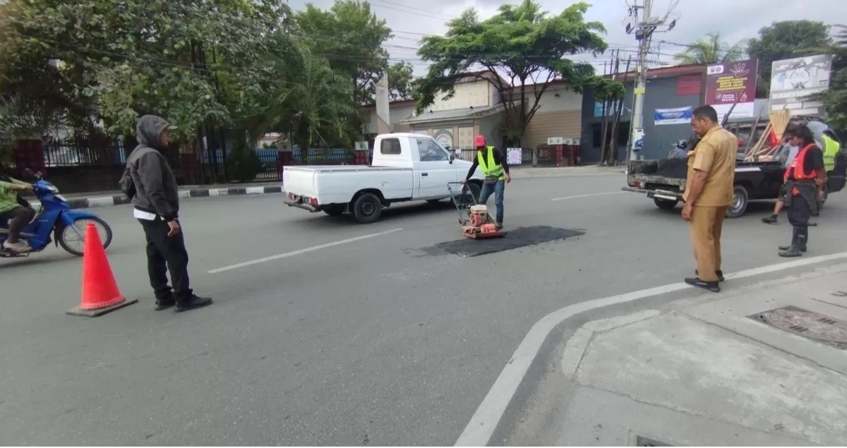 AGAR NYAMAN: Beberapa pekerja melakukan pengaspalan pada titik jalan yang rusak di jalan lingkar Taman Samarinda KEcamatan Samarinda Ulu, Senin (15/7). (FOTO: DENNY SAPUTRA)