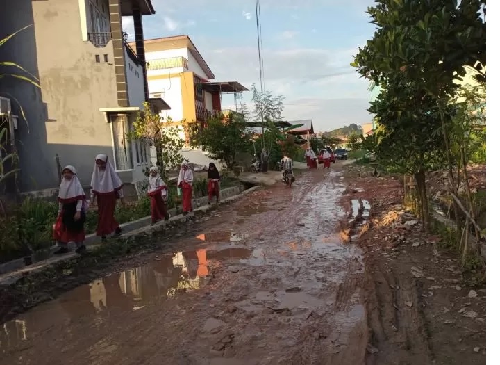 RUSAK. Anak sekolah menghindari jalan rusak yang becek di Jalan Perjuangan 9, Blok D, Kelurahan Sempaja Selatan, Kecamatan Samarinda utara .