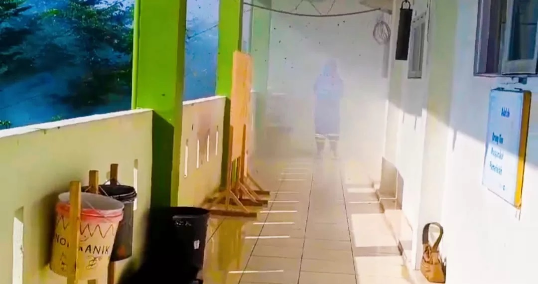 EVAKUASI: Anggota Damkar HSU, melaksanakan evakuasi lebah di lantai tiga SMA di Kecamatan Banjang. (Foto: M.Akbar/Radar Banjarmasin)