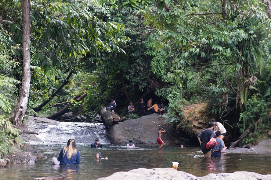Sejumlah pengunjung asik mandi dan berenang di salah satu cekungan antara patahan batuan basal di Jantur Hongkong, Jumat (19/7).